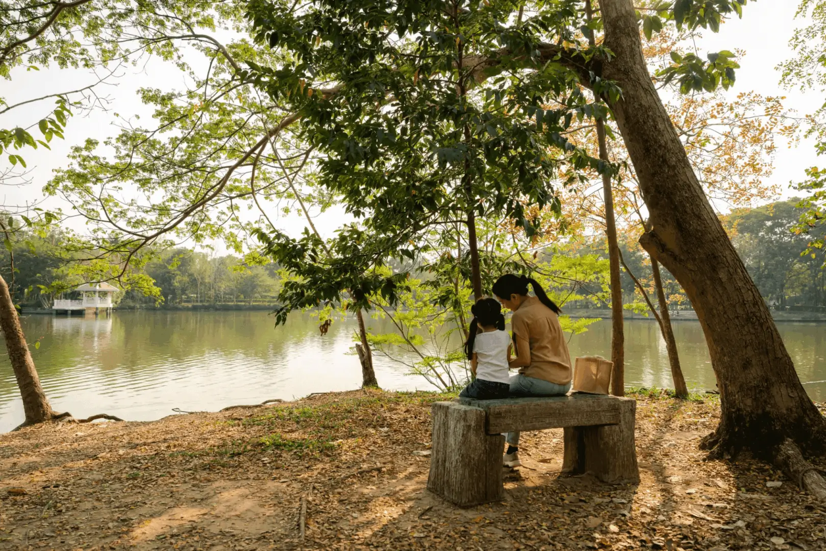 Two people sharing a peaceful moment on a bench by the water.