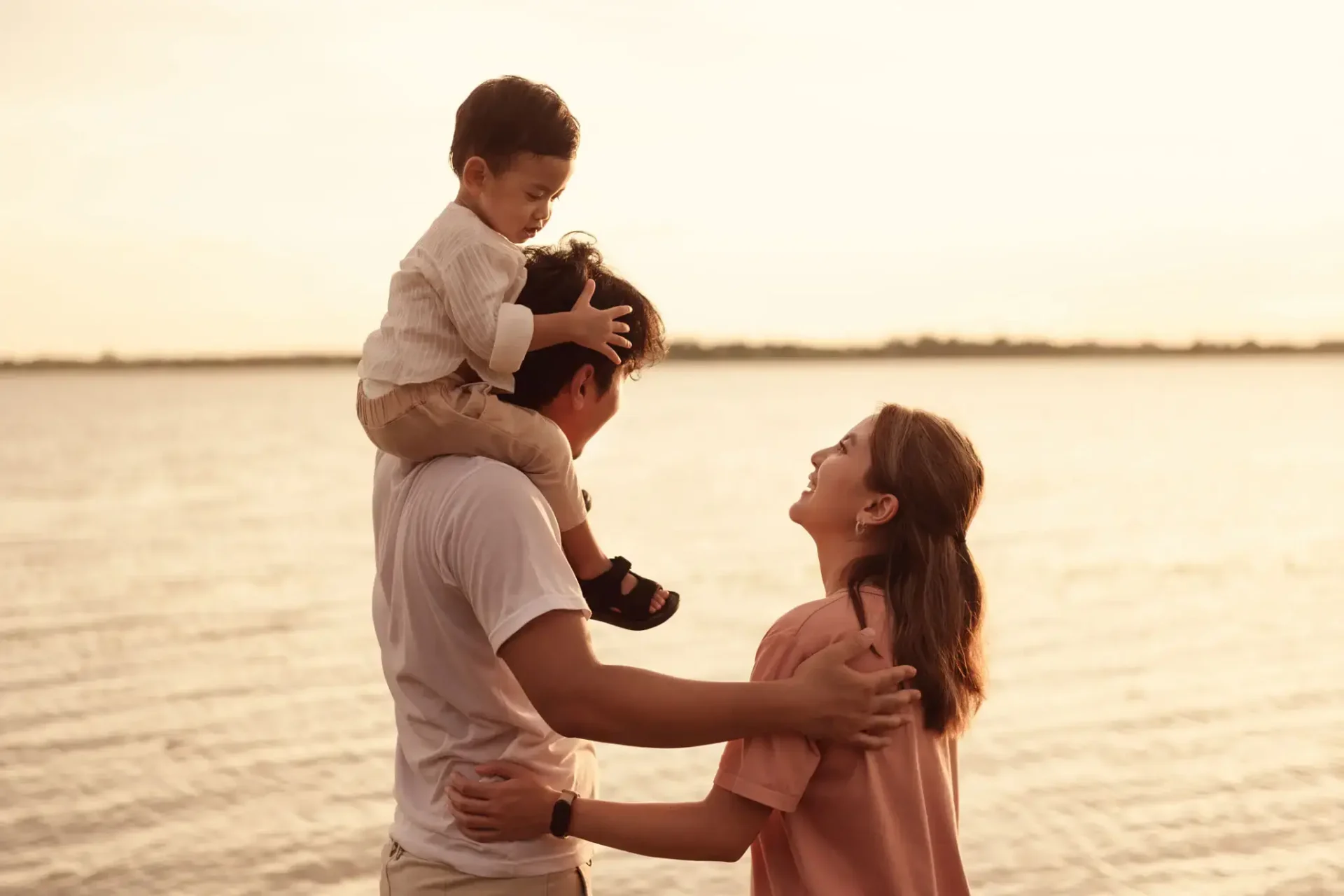 A joyful family moment by the water at sunset.