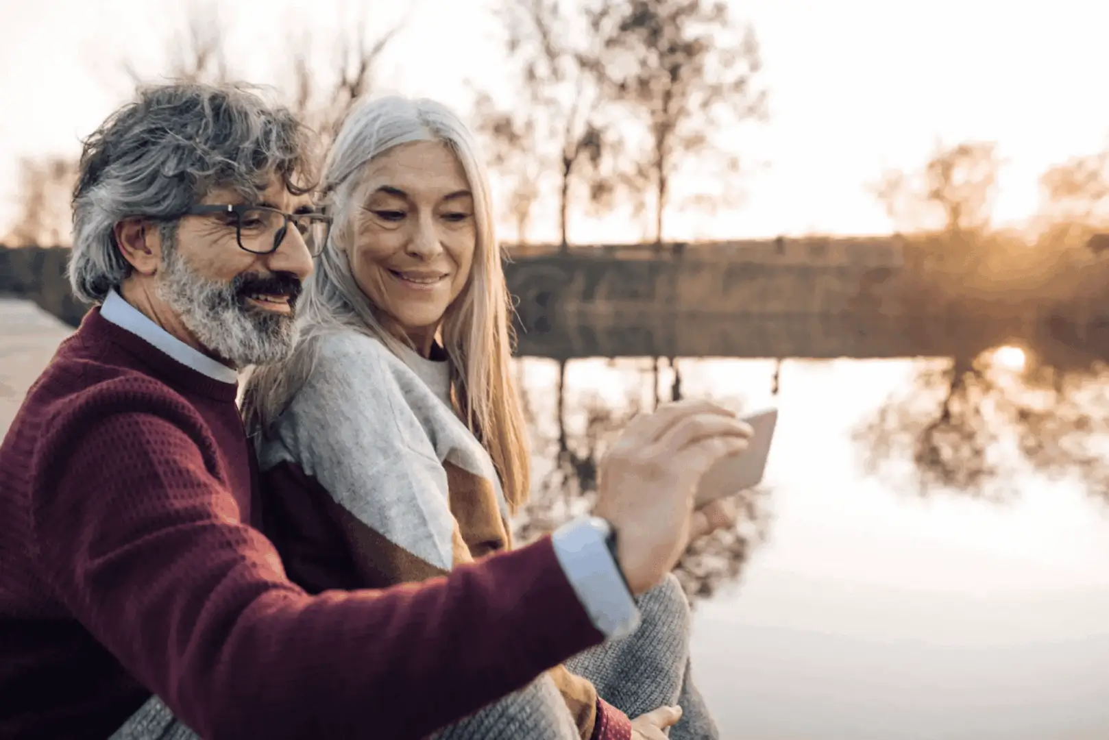 Couple sharing a joyful moment by the water at sunset.